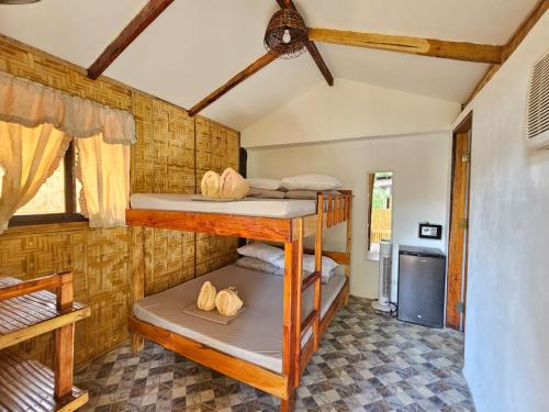 two bunk beds in a room with a kitchen at Big BamBoo Beach Resort Sipalay in Sipalay