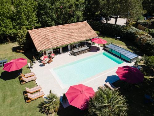 une vue aérienne d'une piscine avec des parasols dans l'établissement Le Domaine de Petiosse, à Saint-Julien-en-Born
