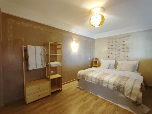 a bedroom with a large white bed and a lamp at Argan surf house in Taghazout