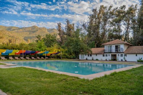 a swimming pool with lawn chairs and umbrellas at Hacienda los Lingues Chile Valle de Colchagua in Los Lingues