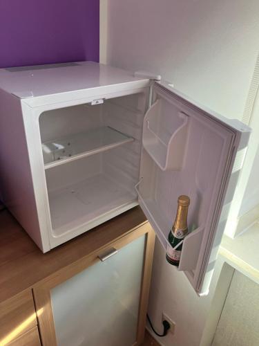 an empty refrigerator with a bottle of beer in it at 1 Privatzimmer möbliert gut ausgestattet und gute Anbindung Bus Bahn in Hohenbrunn