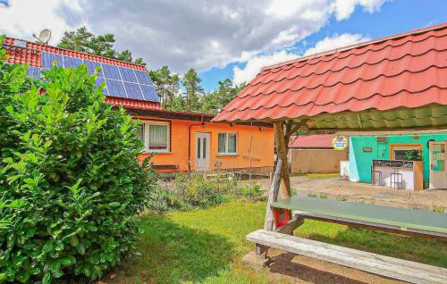 una casa con un tetto rosso con una panchina davanti di Ferienwohnung Milmersdorf a Milmersdorf