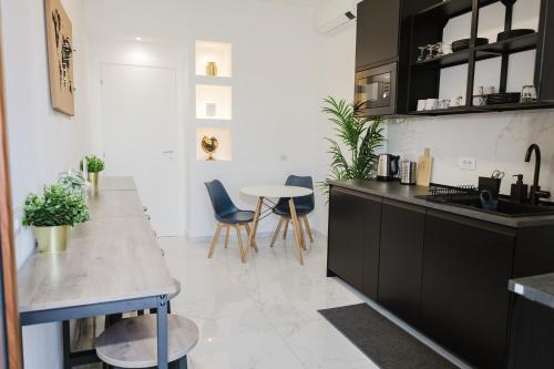 a kitchen with black cabinets and a table and chairs at B&B Best Hostel Milano in Milan