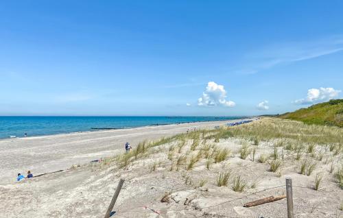 a beach with people on the sand and the ocean at Ferienwohnung Graal-Müritz in Graal