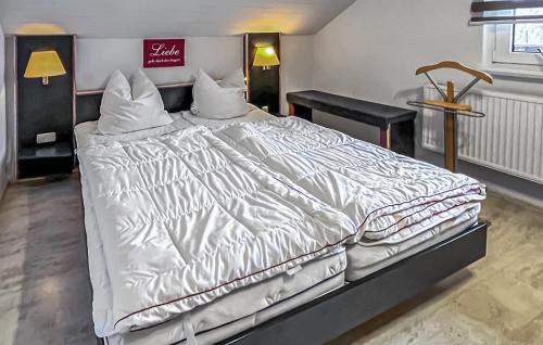 a large bed with white sheets and pillows at Ferienwohnung Graal-Müritz in Graal