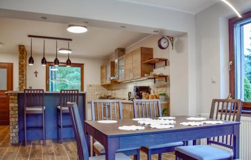 a kitchen and dining room with a blue table and chairs at 2 Bedroom Awesome Home In Gorzkie Pole in Wronczyn