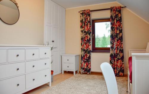a bedroom with a dresser and a window at 2 Bedroom Awesome Home In Gorzkie Pole in Wronczyn