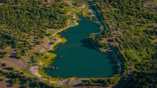 an aerial view of a lake in a forest at Hacienda los Lingues Chile Valle de Colchagua in Los Lingues