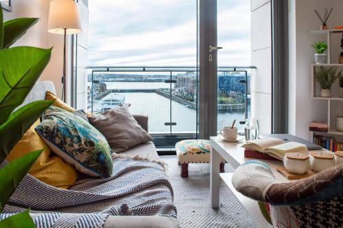 a living room with a couch and a large window at Stunning Mersey View Flat W Parking In Liverpool in Liverpool