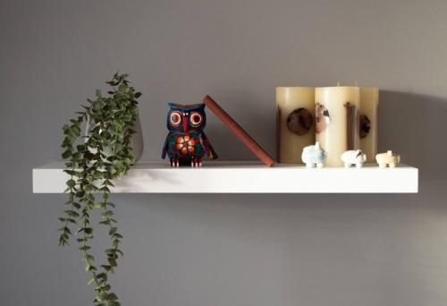 a shelf with an owl and other items on it at Stunning Mersey View Flat W Parking In Liverpool in Liverpool