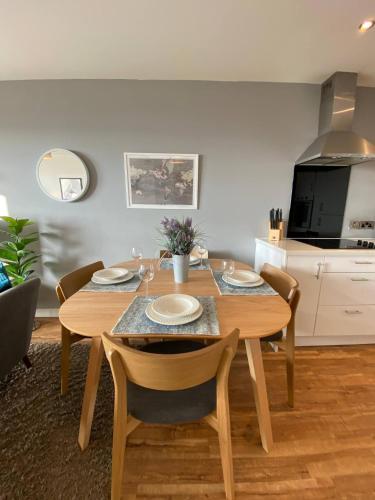 a dining room with a wooden table and chairs at Stunning Mersey View Flat W Parking In Liverpool in Liverpool