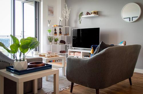 a living room with a chair and a television at Stunning Mersey View Flat W Parking In Liverpool in Liverpool