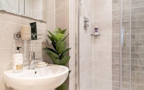 a bathroom with a sink and a shower at Stunning Mersey View Flat W Parking In Liverpool in Liverpool