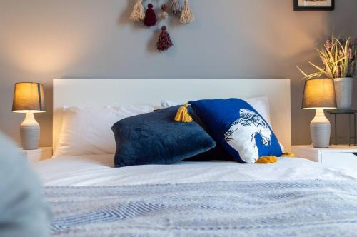 a bed with two blue pillows on top of it at Stunning Mersey View Flat W Parking In Liverpool in Liverpool