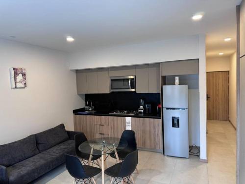 Una sala de estar con un sofá y una mesa y una cocina. en Loft Sant Marteen - Americana, en Guadalajara