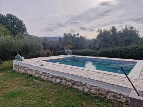 a swimming pool with a stone wall around it at Country House with Pool in Nerola in Nerola