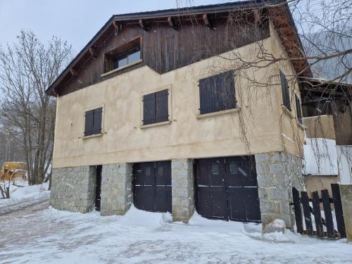 a building with two garage doors in the snow at Chalet Catalan proche des pistes in Porta