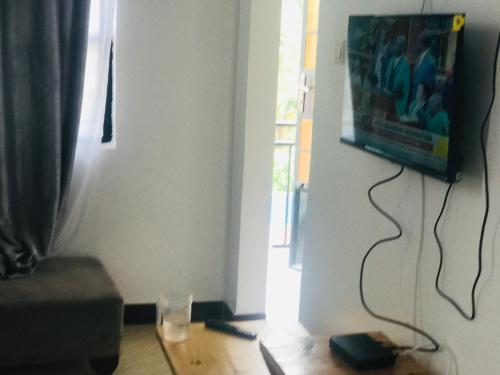 a living room with a tv hanging on a wall at Bethlehem home in Arusha