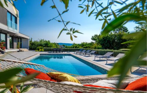 una piscina con sedie e amaca accanto a una casa di 4 Bedroom Stunning Home In Rakalj a Rakalj