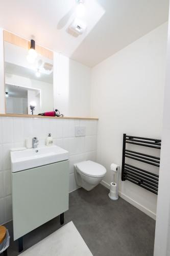 une salle de bain blanche avec des toilettes et un lavabo dans l'établissement Massy Palaiseau TGV - Rer B&C - Free Parking, à Palaiseau