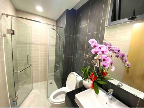 a bathroom with a toilet and a glass shower at Luxury Apartment Asiana Capella Trung tâm Chợ lớn in Ho Chi Minh City
