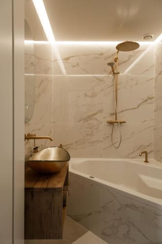 a bathroom with a tub and a bowl on a wooden counter at Boutique Hotel Elburg met Tapperij in Elburg