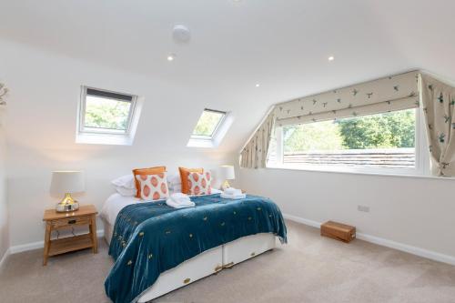 a bedroom with a bed with a blue comforter and a window at The Lawley in Shrewsbury