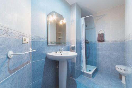 a blue bathroom with a sink and a toilet at Apartamento Vistas y Chimenea in Benaocaz
