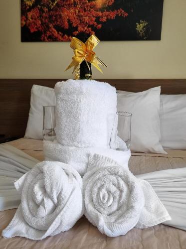 a pile of towels sitting on top of a bed at Pousada Coqueiral in Aracruz