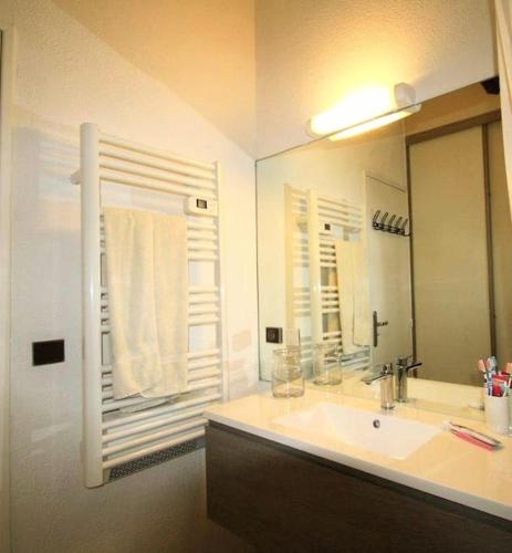 une salle de bain avec un lavabo et un grand miroir dans l'établissement 42 m2 d'élégance avec terrasse, parking, belle vue, à Collioure