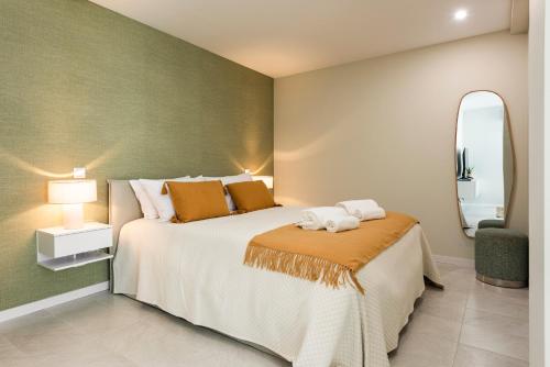 a bedroom with a large bed and a mirror at Villa 41 - Private Studios Faro Airport, Beach and City Center in Faro