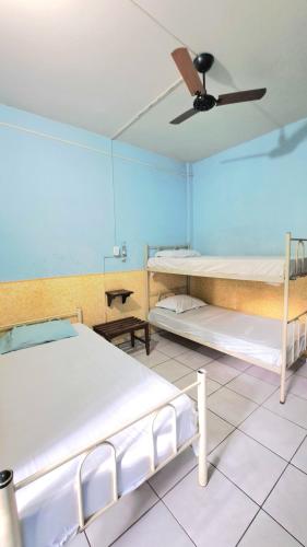 two beds in a room with a ceiling fan at Príncipe Hotel Maringá in Maringá