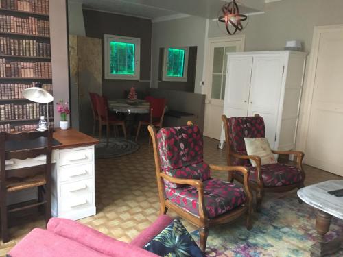 - un salon avec des chaises, un bureau et une table dans l'établissement Le gîte du familistère -399, à Guise