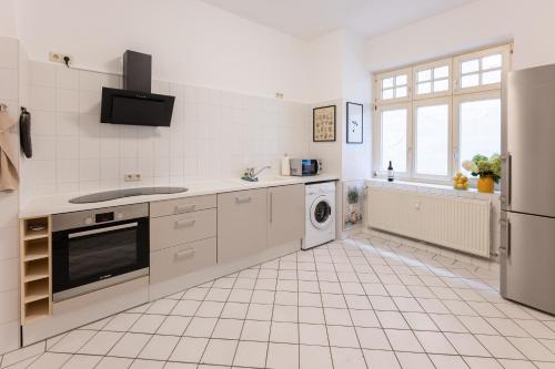 a white kitchen with a sink and a dishwasher at Gästehaus am Winckel in Stendal