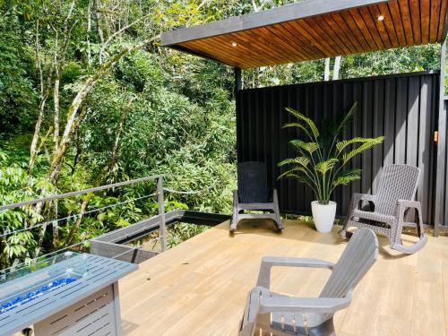 a deck with two chairs and a swimming pool at Serenity Glampings Quinta Montaña in Cóbano