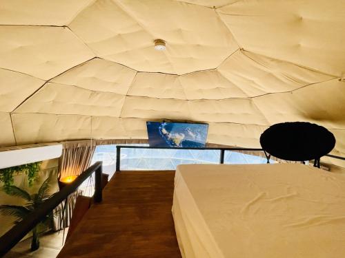 a room with a ceiling with a table and a laptop at Serenity Glampings Quinta Montaña in Cóbano