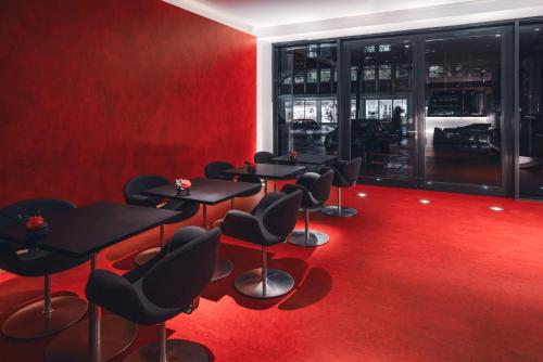 a red room with tables and chairs on a red carpet at Hotel Q! Berlin in Berlin