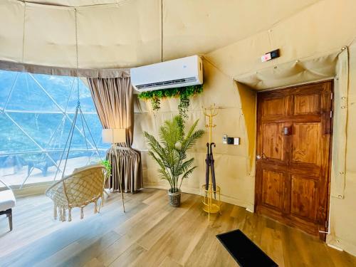 a living room with a large window and a wooden door at Serenity Glampings Quinta Montaña in Cóbano