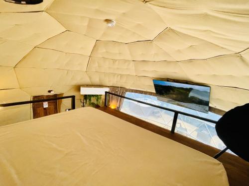 a bedroom with a large bed and a large window at Serenity Glampings Quinta Montaña in Cóbano