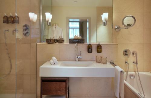 a bathroom with a sink and a shower at Hotel Alden Splügenschloss Zürich - Leonardo Limited Edition in Zürich