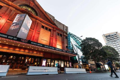 a man walking in front of a building at The Capitol Hotel Sydney in Sydney