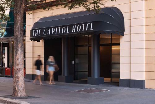 two people walking in front of a hotel at The Capitol Hotel Sydney in Sydney