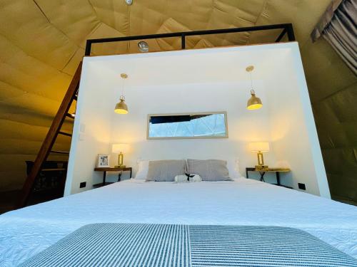 a bedroom with a large bed in a tent at Serenity Glampings Quinta Montaña in Cóbano