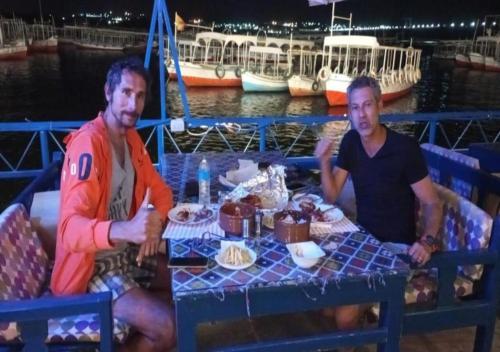 two men sitting at a table on a boat at Endo Mando in Shellal