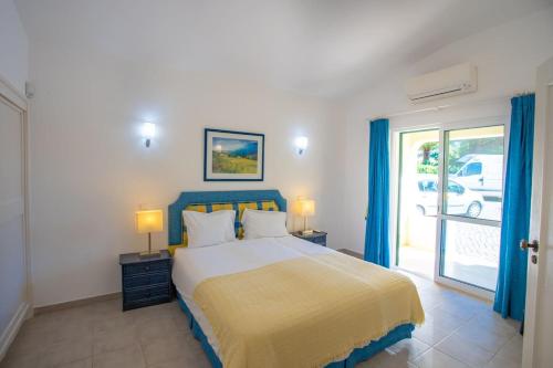 a bedroom with a large bed with blue curtains at 7 Club Atlantico - Wonderful five-bedroom villa in Carvoeiro