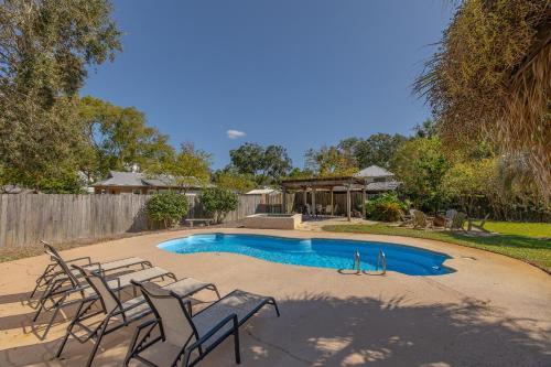 ein Swimmingpool mit Stühlen und einem Pavillon in der Unterkunft Milly by the Sea in Saint Simons Island