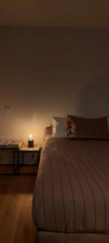 a person laying on a bed with a candle at Retiro Studio 34 in Guimarães