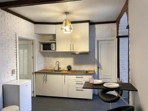 サンルーカル・デ・バラメダにあるApartamento Plaza del Cabildo - Sanlúcar Centroのキッチン(白いキャビネット、テーブル、シンク付)