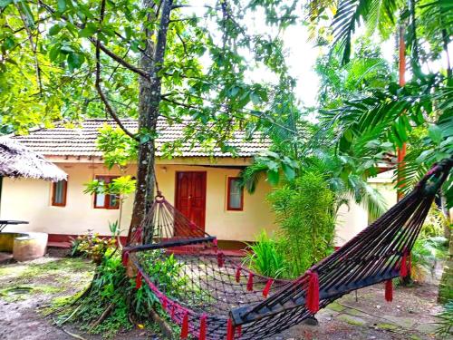 a house with a hammock in front of it at New Kahuna Cabanas in Unawatuna