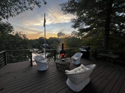 a deck with a table and chairs with a fire at Waterfront Lakehouse Getaway in Clinton with HOT TUB in Clinton